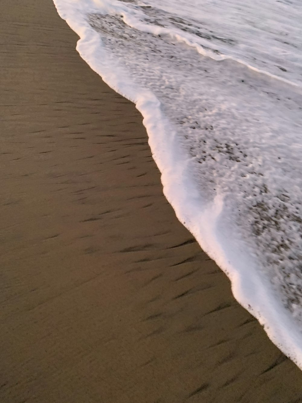 ocean waves crashing on shore during daytime