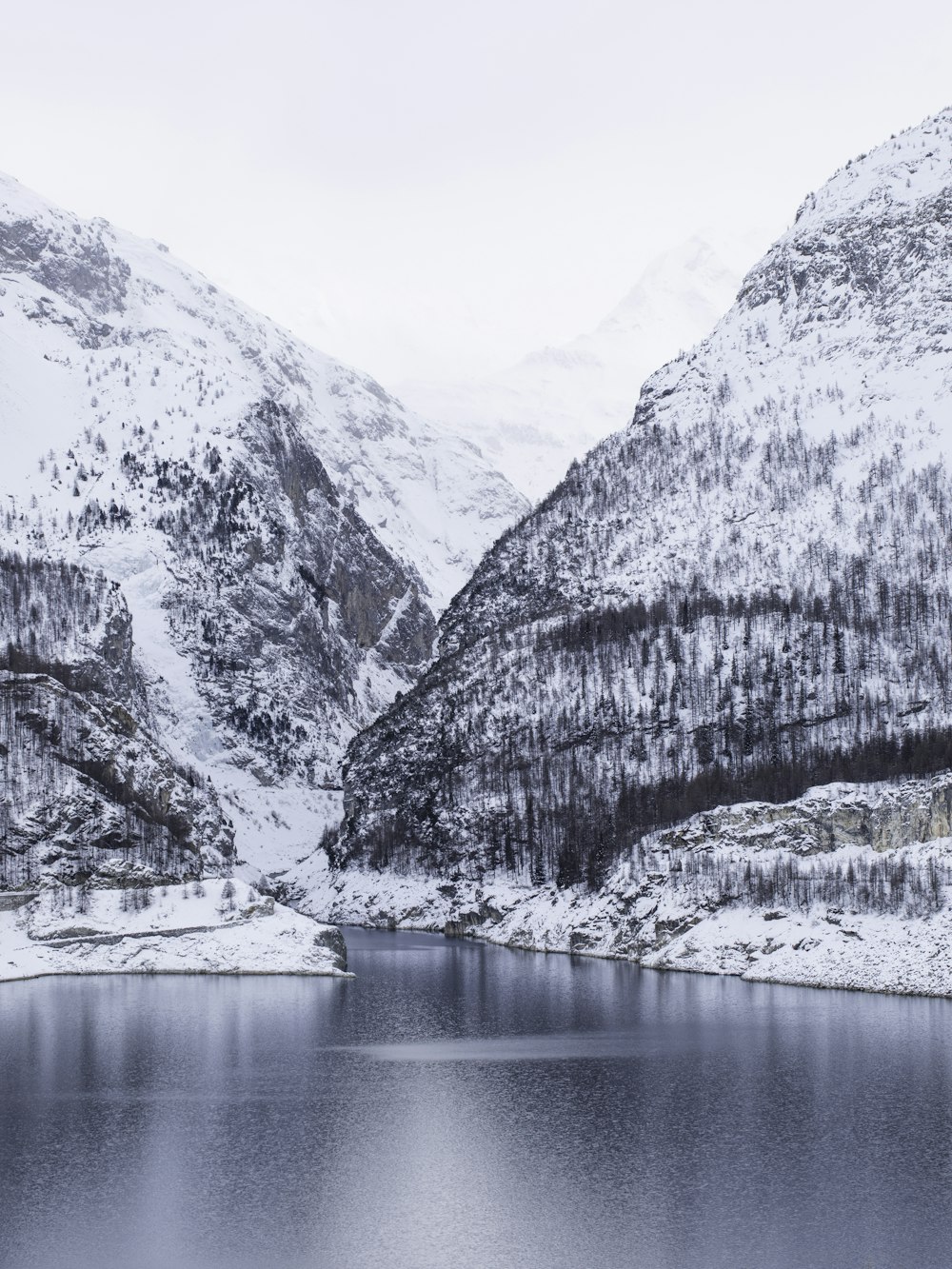 white and gray mountain beside body of water