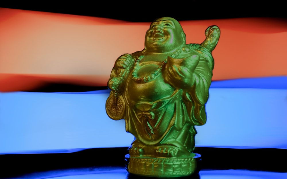 green ceramic figurine on blue surface