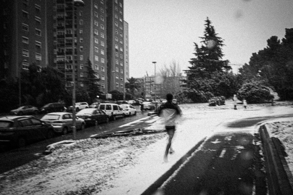 grayscale photo of woman walking on road