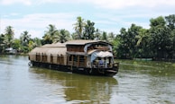 A traditional Kerala houseboat floating gently on the backwaters at sunrise.