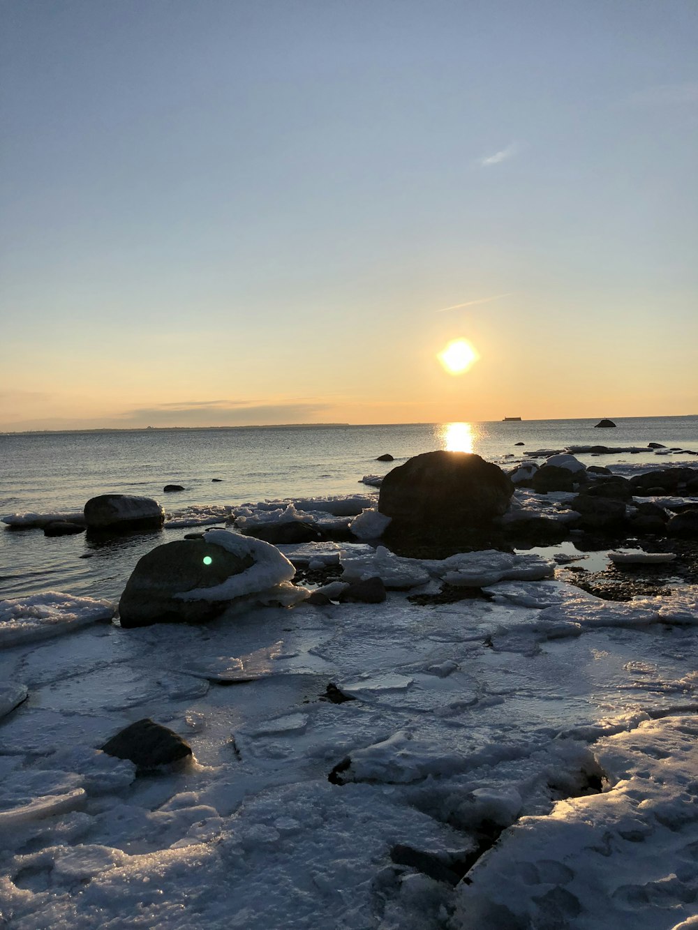 black rocks on sea shore during sunset