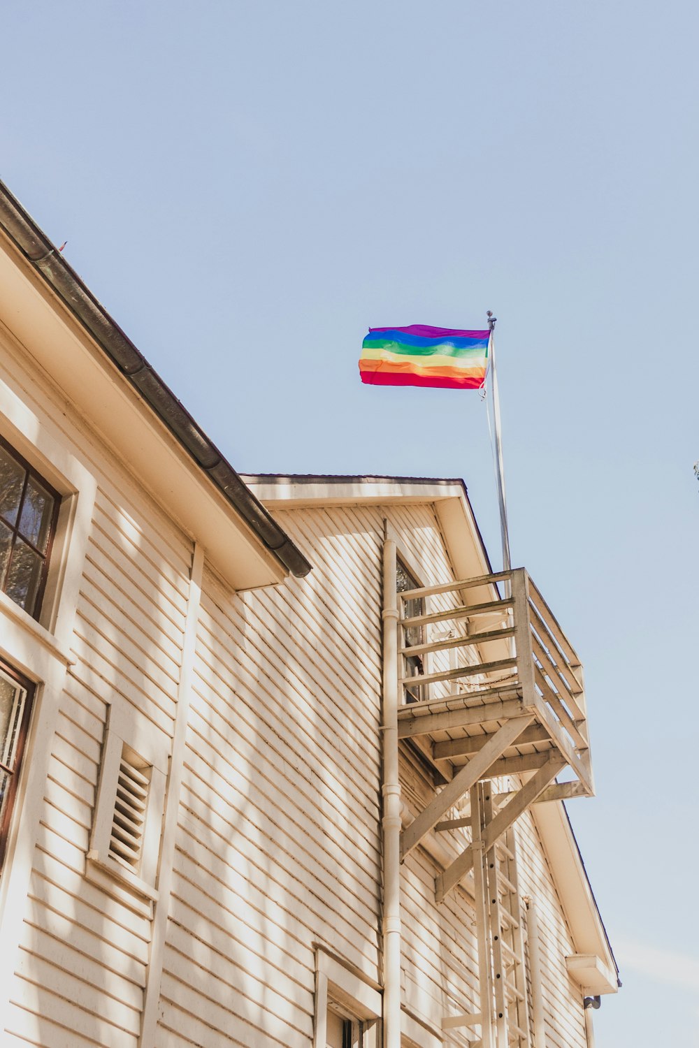 white and brown wooden house with flag on top during daytime