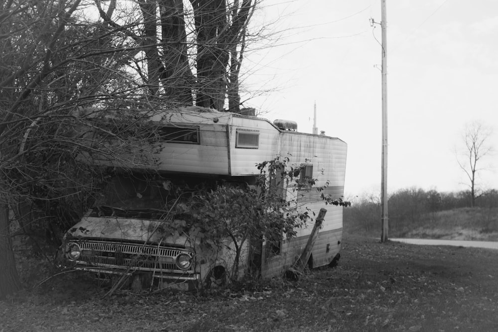 grayscale photo of a house near bare trees