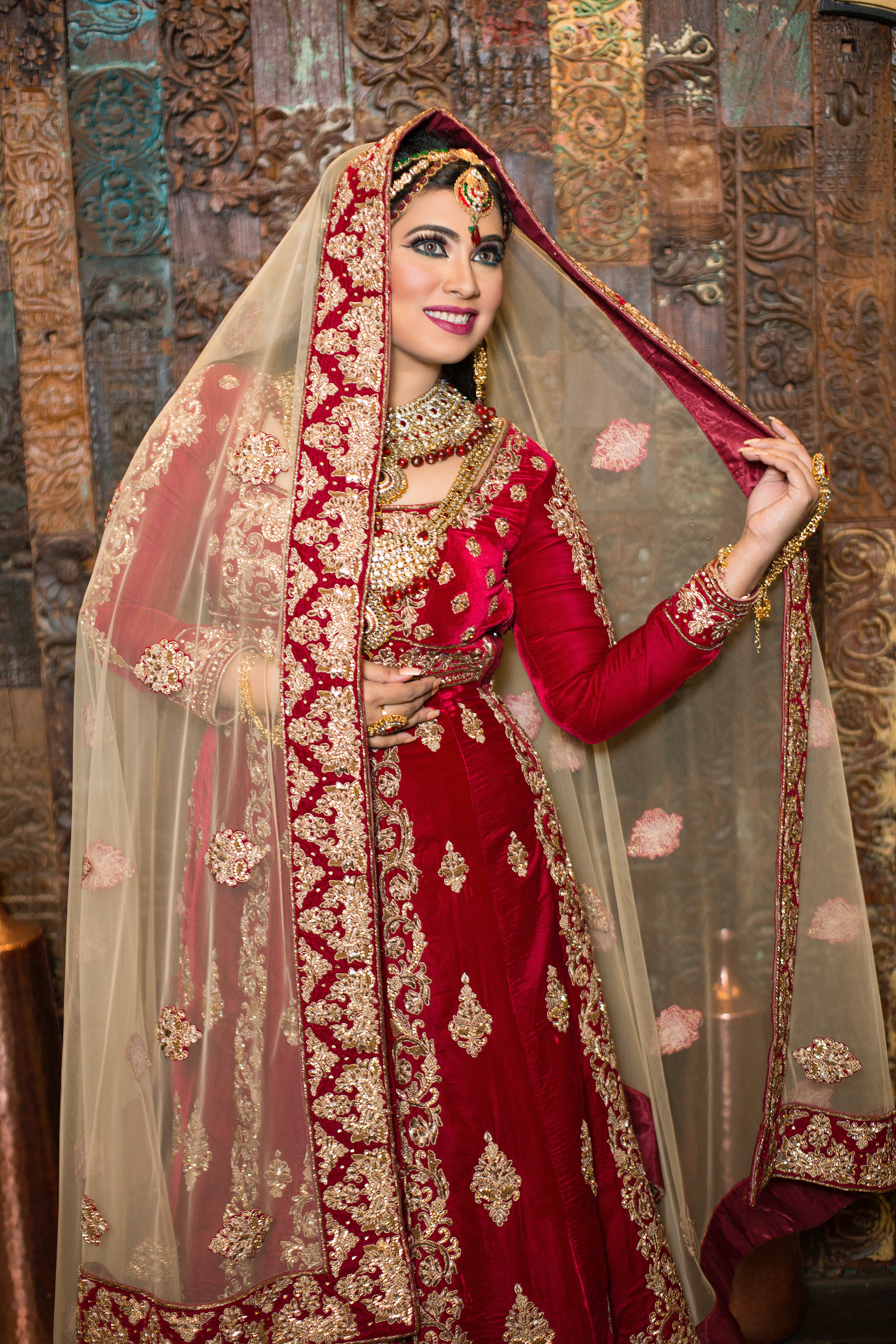 Bride drawing an ivory embroidered dupatta around her
