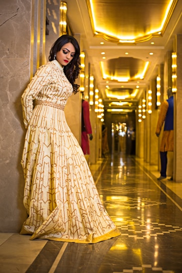 Elegant woman in a flowing silk dress standing in a softly lit luxury boutique