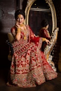 woman in red and gold floral dress sitting on brown wooden armchair