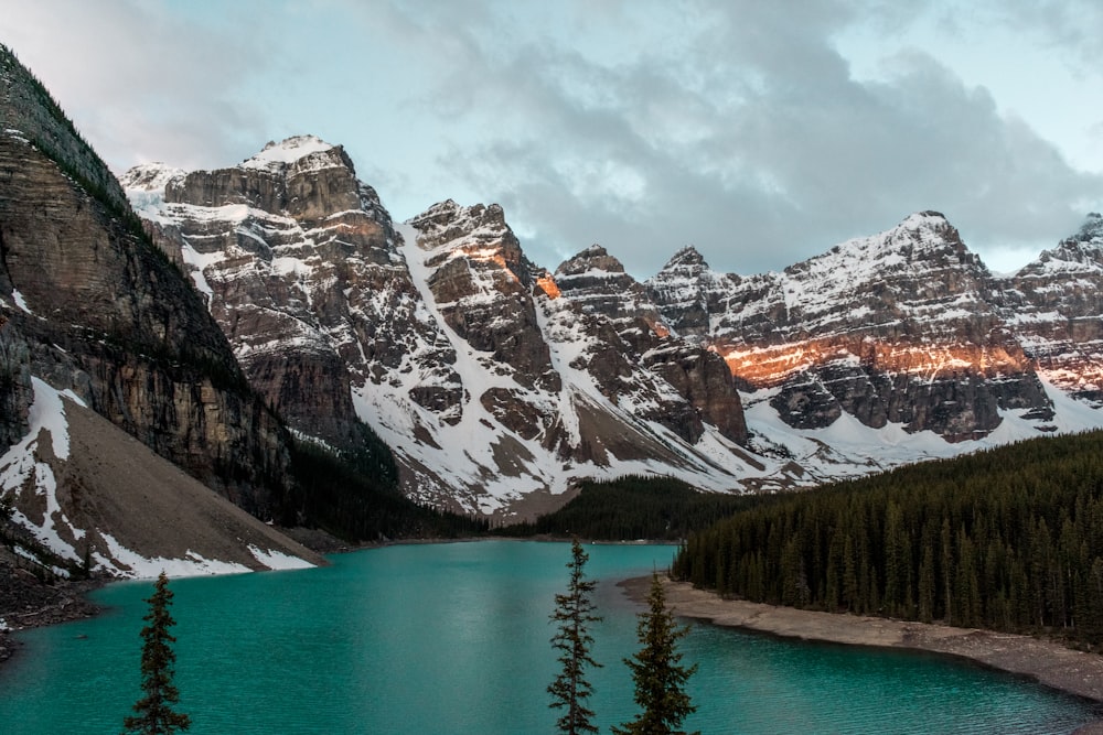 lago perto da montanha coberta de neve durante o dia