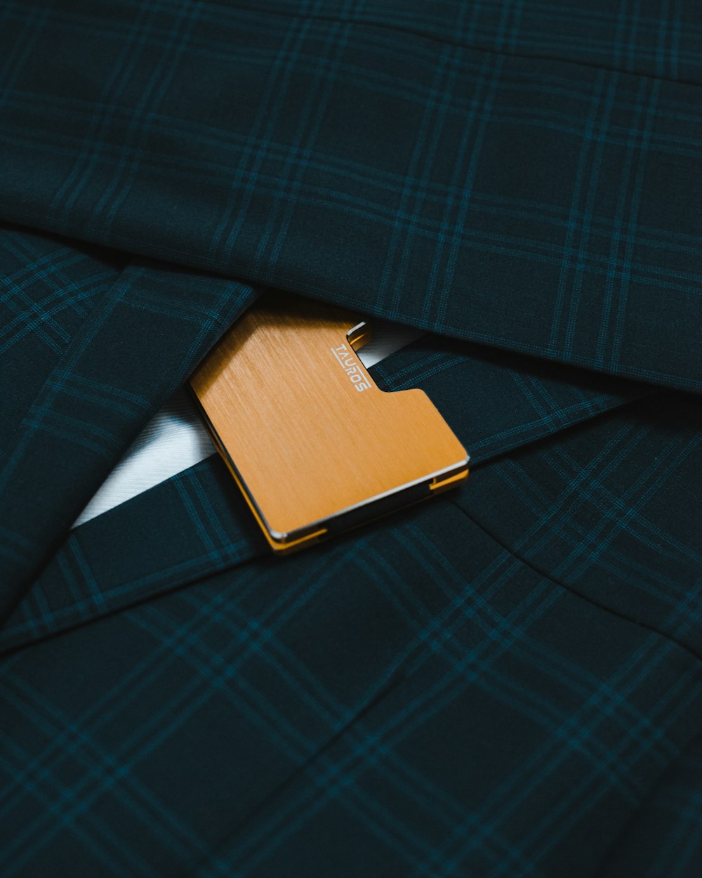 braunes Leder-Flipcover auf blau und schwarz kariertem Textil