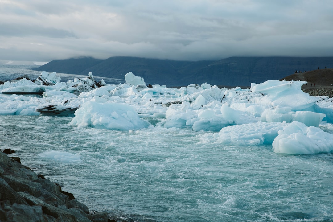 ice on rocky shore under cloudy sky during daytime