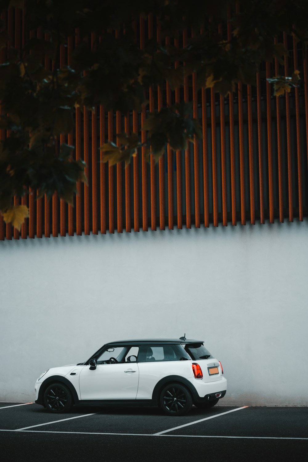 white car parked beside brown wall