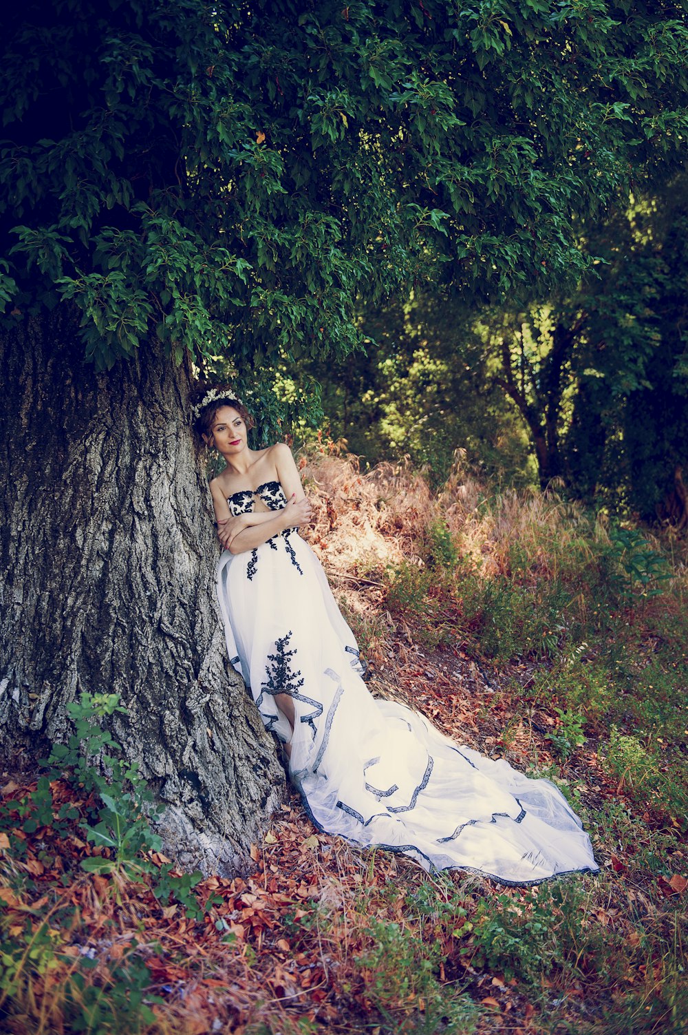 woman in white dress sitting on tree trunk