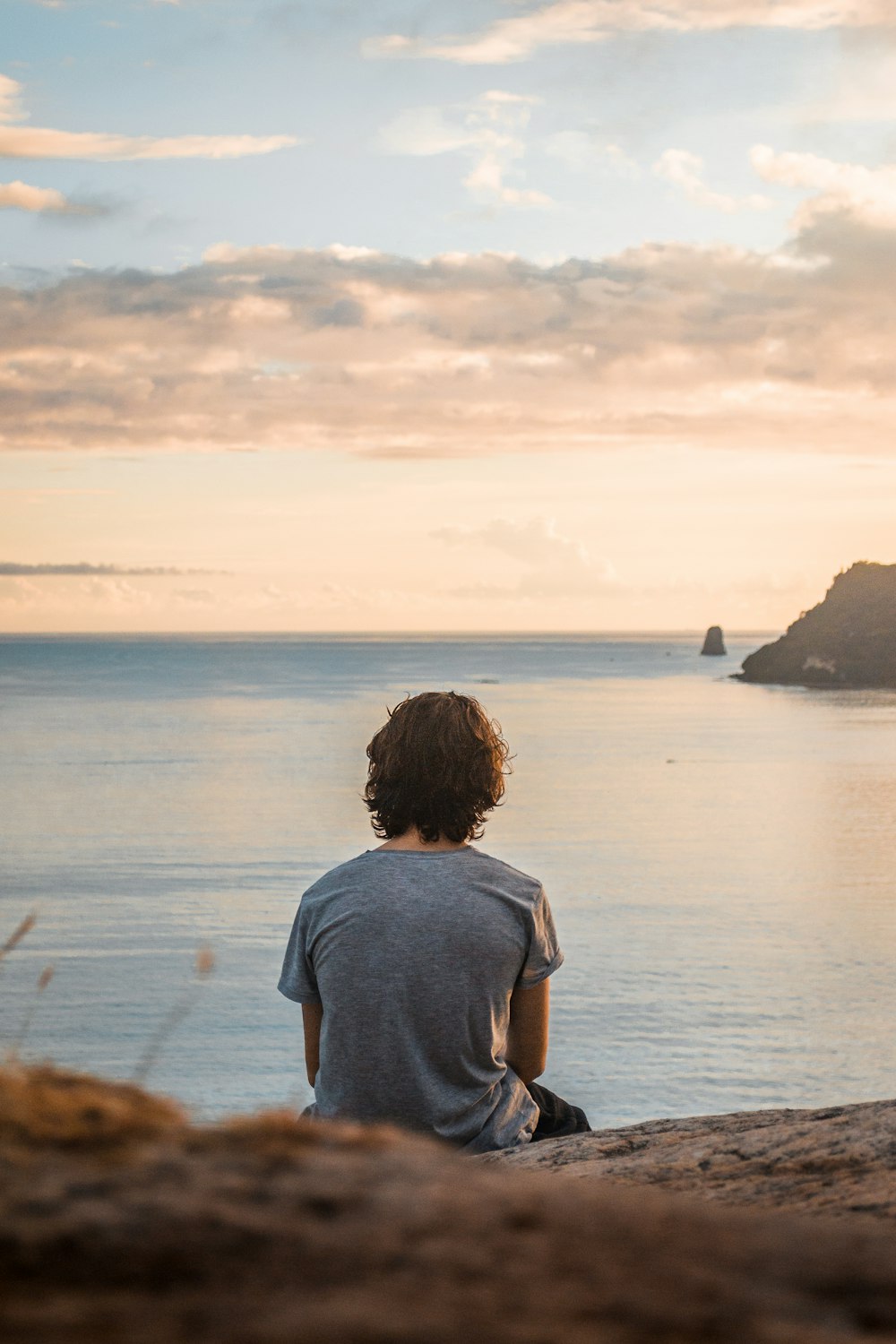 man in gray t-shirt standing near body of water during daytime