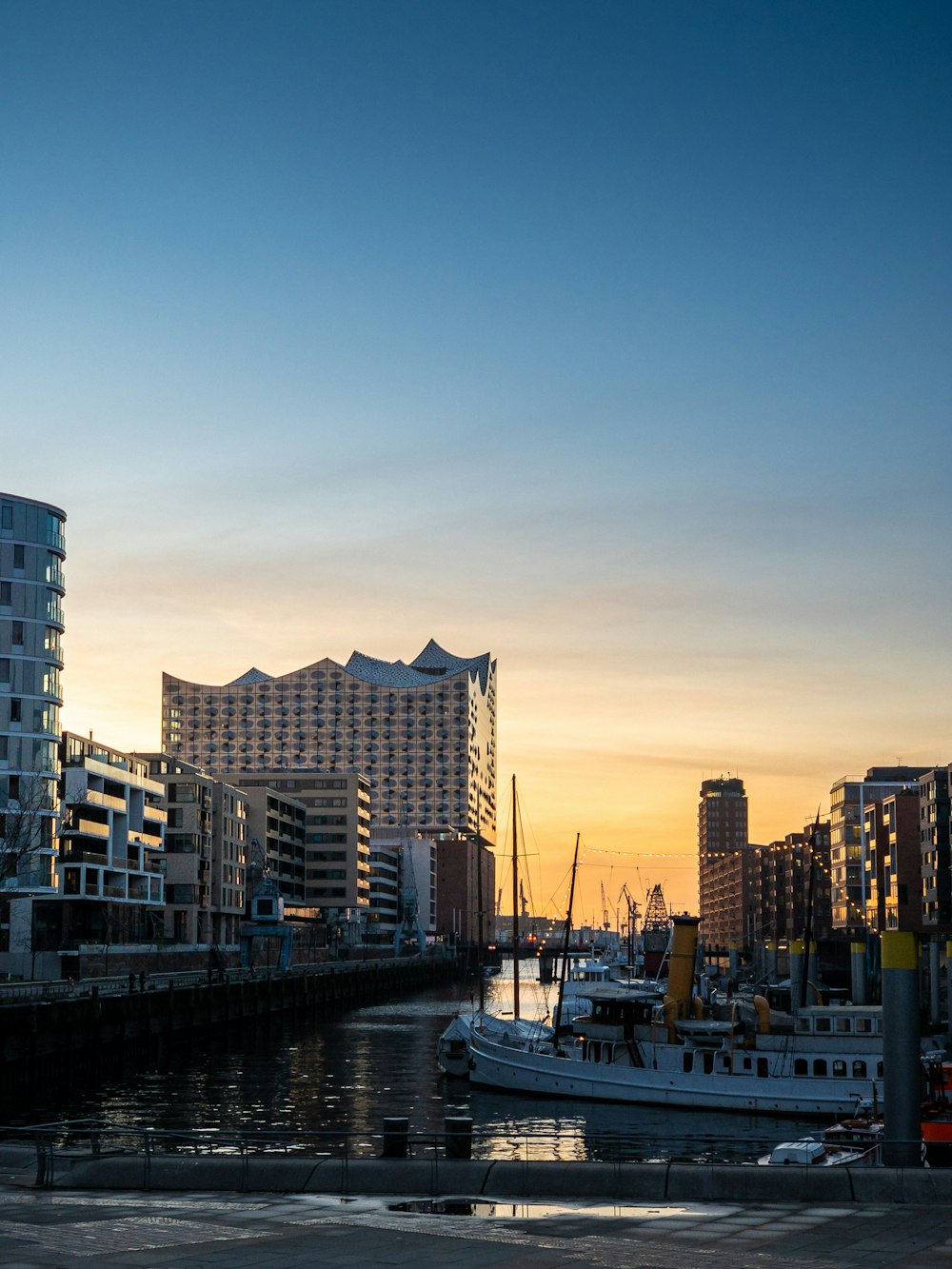 white boat on body of water near city buildings during daytime