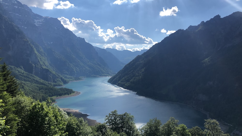 lake between mountains under blue sky during daytime