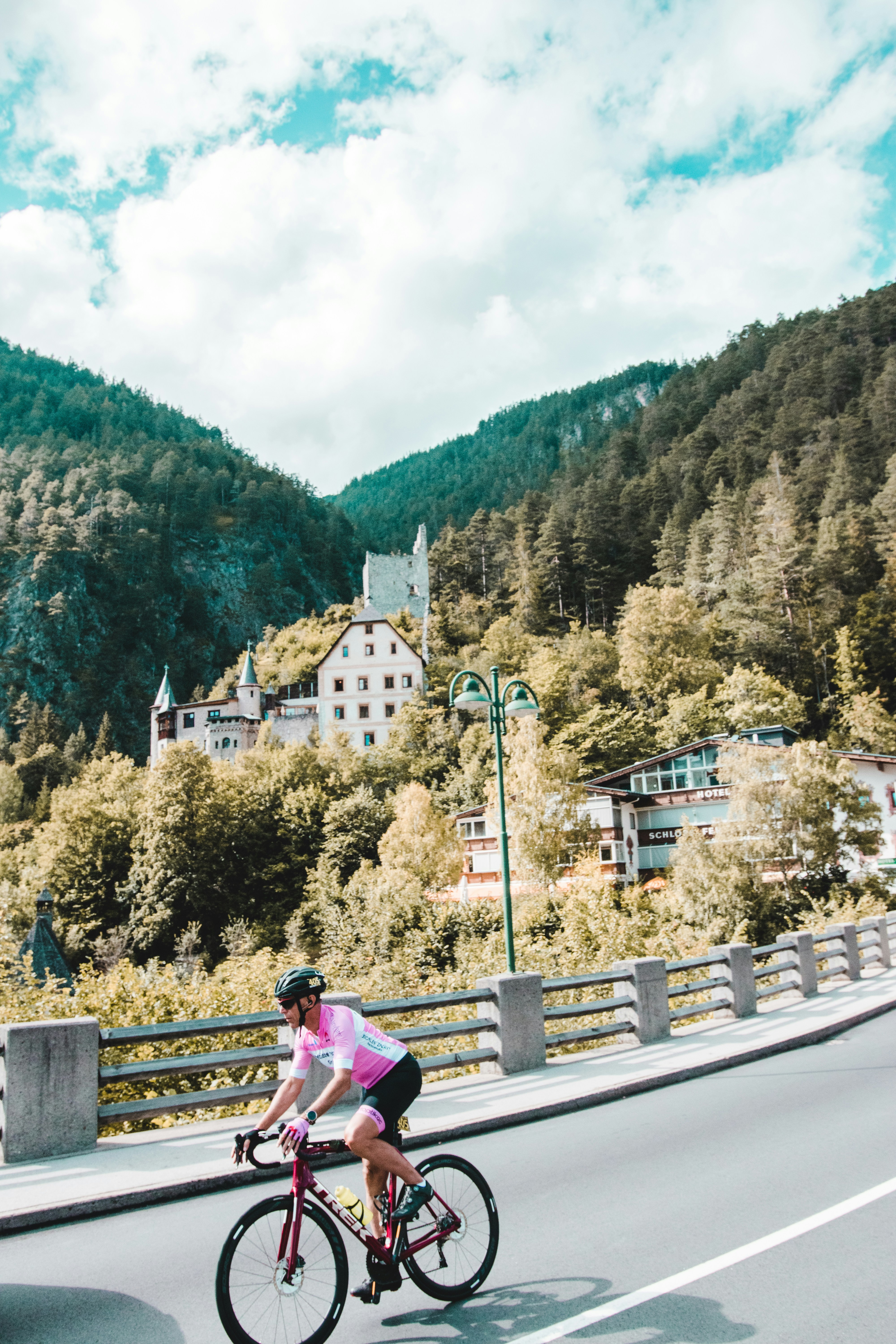 woman in pink jacket sitting on brown wooden bench