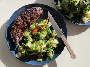 cooked meat with vegetable on black plate