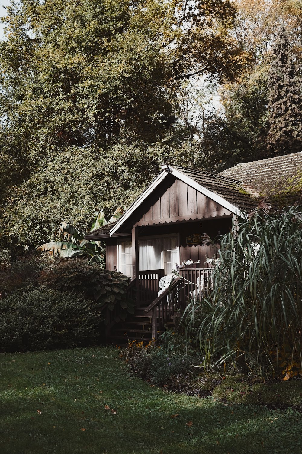 brown wooden house surrounded by green trees during daytime