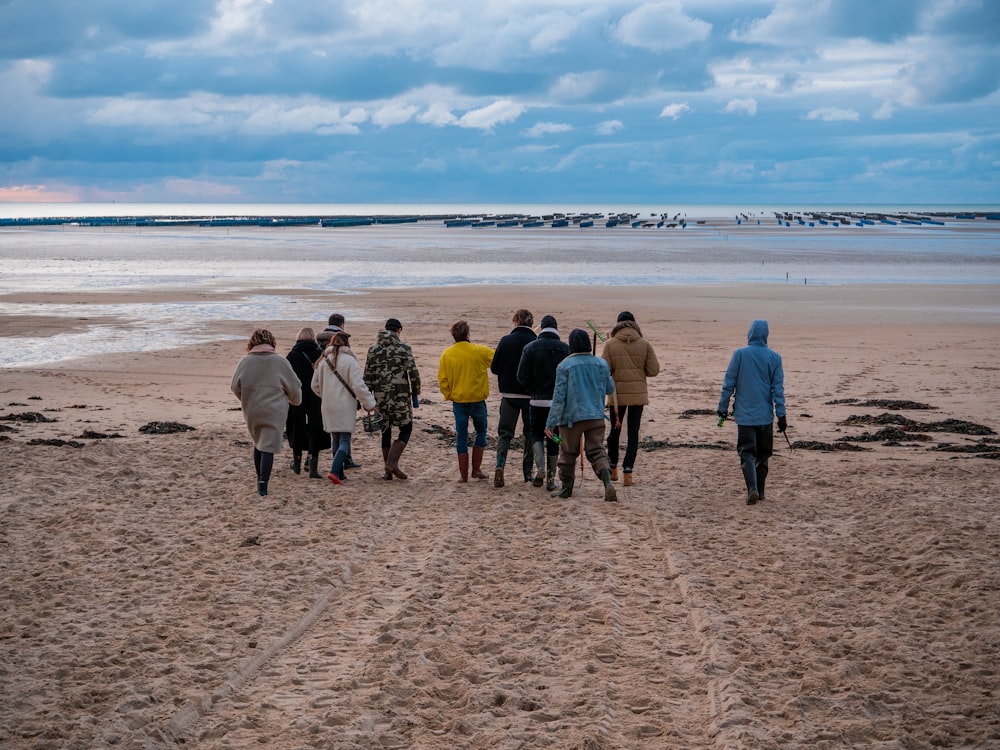 Gruppe von Menschen, die tagsüber am Strand stehen
