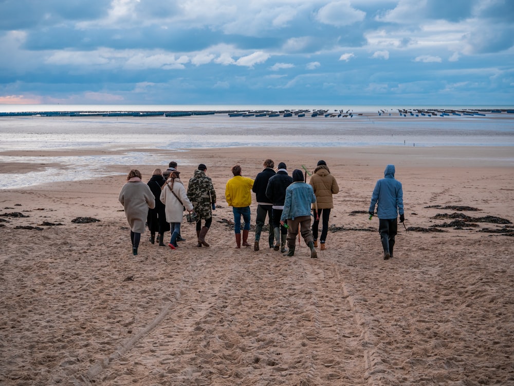 group of people standing on beach during daytime