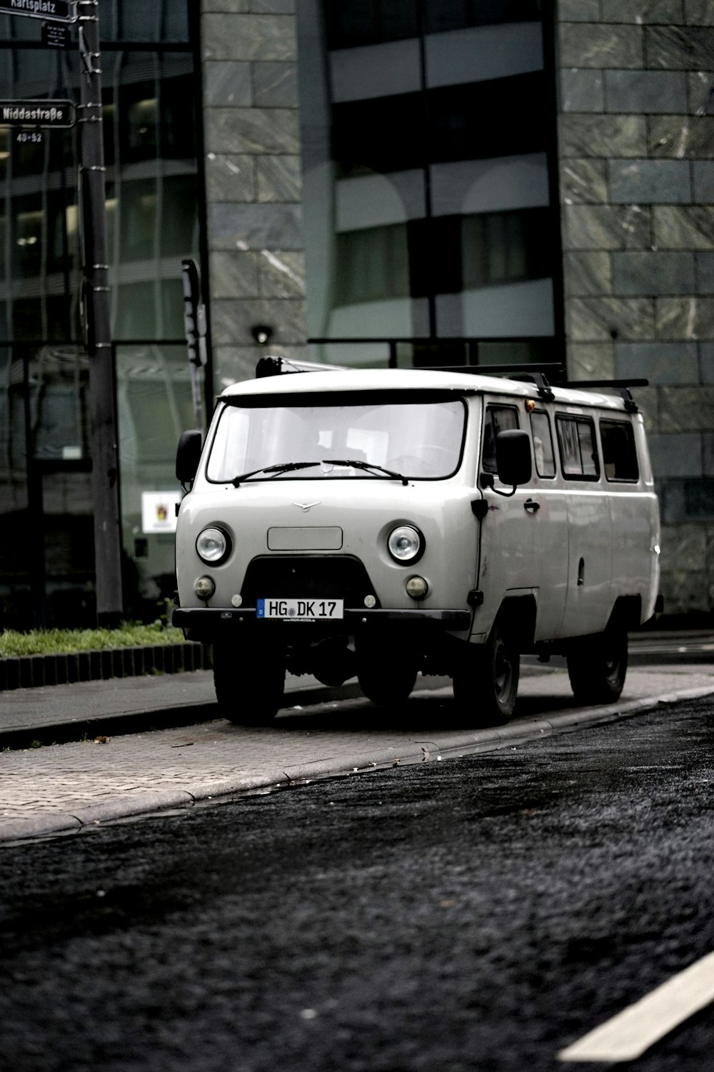 white volkswagen t-2 parked beside green and brown concrete building during daytime