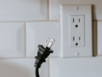 black usb cable plugged in white electric socket