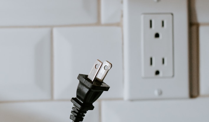 black usb cable plugged in white electric socket