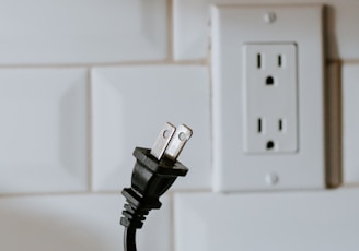 black usb cable plugged in white electric socket