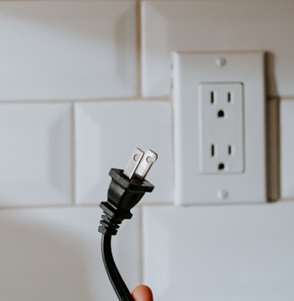 black usb cable plugged in white electric socket