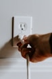 person holding white electric plug