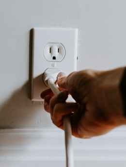 person holding white electric plug