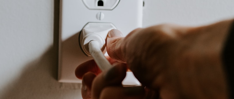 person holding white electric plug