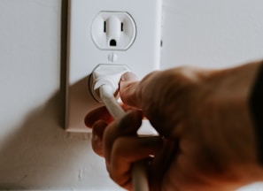 person holding white electric plug