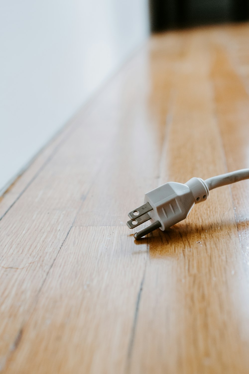 Weißes USB-Kabel auf braunem Holztisch