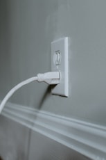 white usb cable plugged in white electric socket