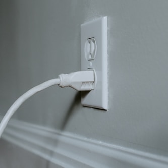 white usb cable plugged in white electric socket