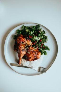 A colorful plate featuring roasted chicken with herbs and a side of fresh salad.