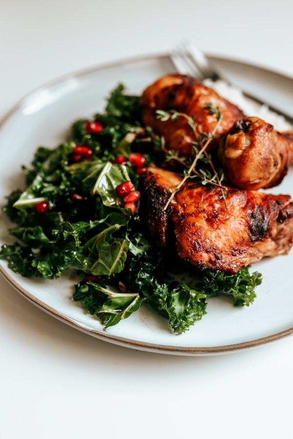 Cooked meat with green vegetable on white ceramic plate