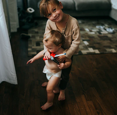 girl in brown long sleeve shirt and white shorts sitting on brown wooden floor