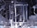A complex arrangement of mechanical parts and components, including metal rods, pipes, and various interconnected structures. The image displays an intricate assembly of machinery with a metallic sheen and various textures, indicative of industrial engineering.