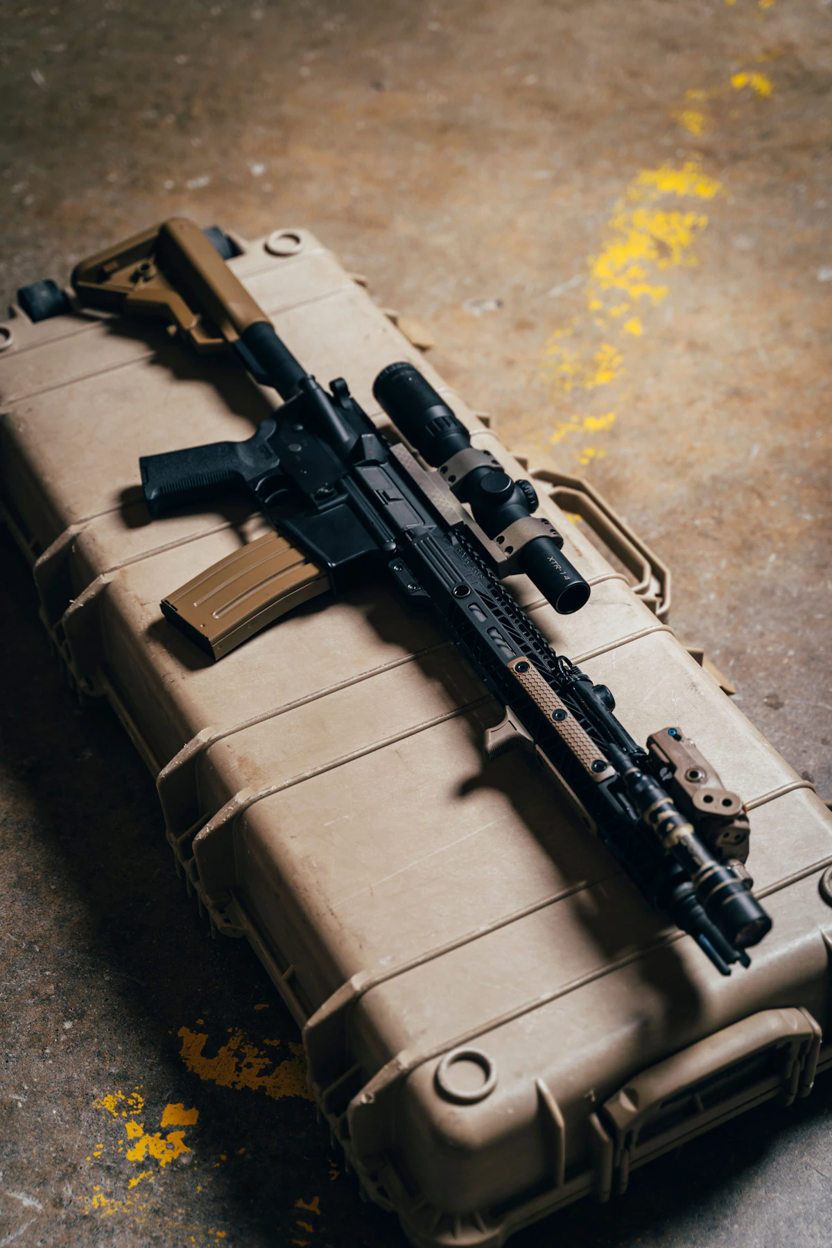 Estuche rígido arena sobre piso de concreto, con rifle y accesorios.