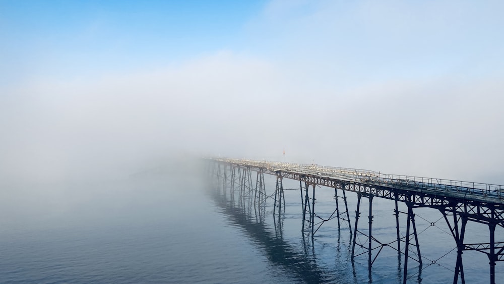 gray wooden dock on sea under blue sky during daytime