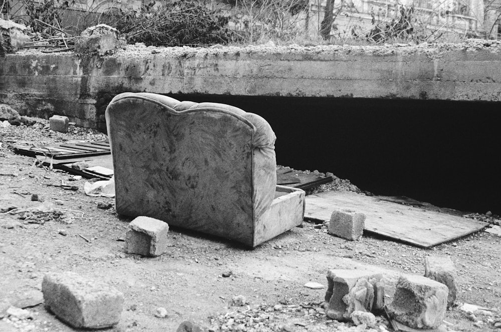 foto in scala di grigi di una panchina in cemento