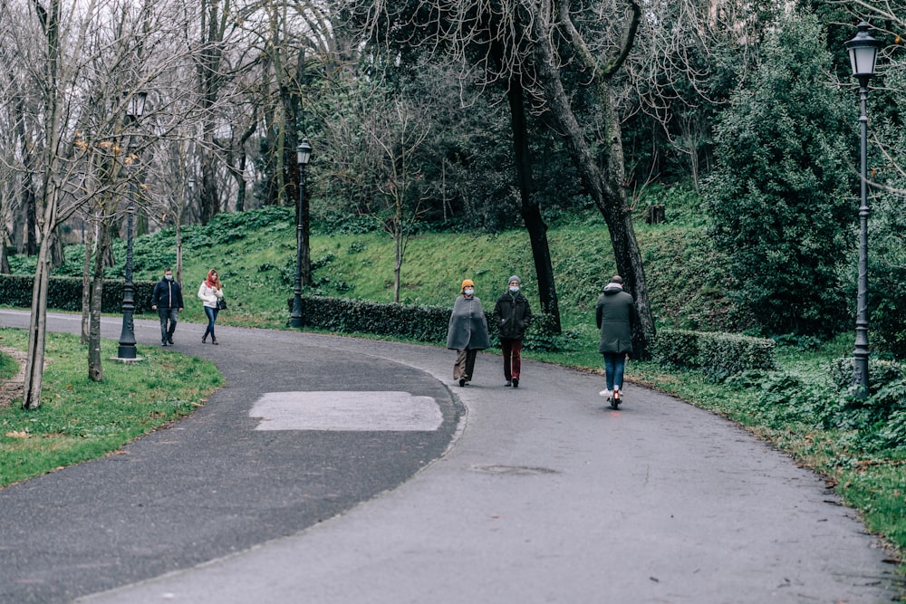 personnes marchant sur une route en béton gris pendant la journée