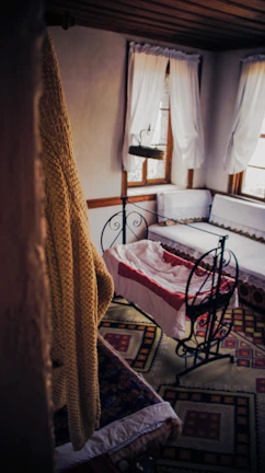 Cozy baby nursery corner with a terracotta and sage crochet blanket draped over a wooden crib.