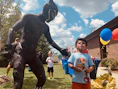 A joyful child meeting a superhero in costume, sharing smiles and laughter.