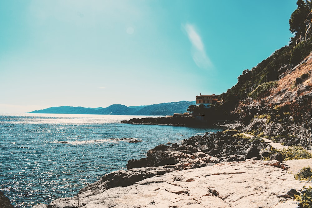 body of water near mountain during daytime