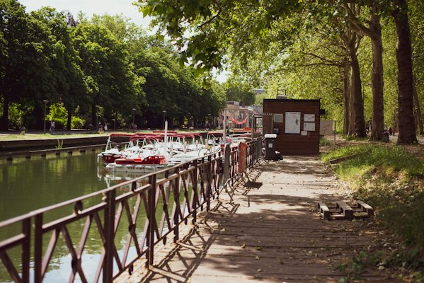 A canal lined with trees, with boats moored — Lille, France