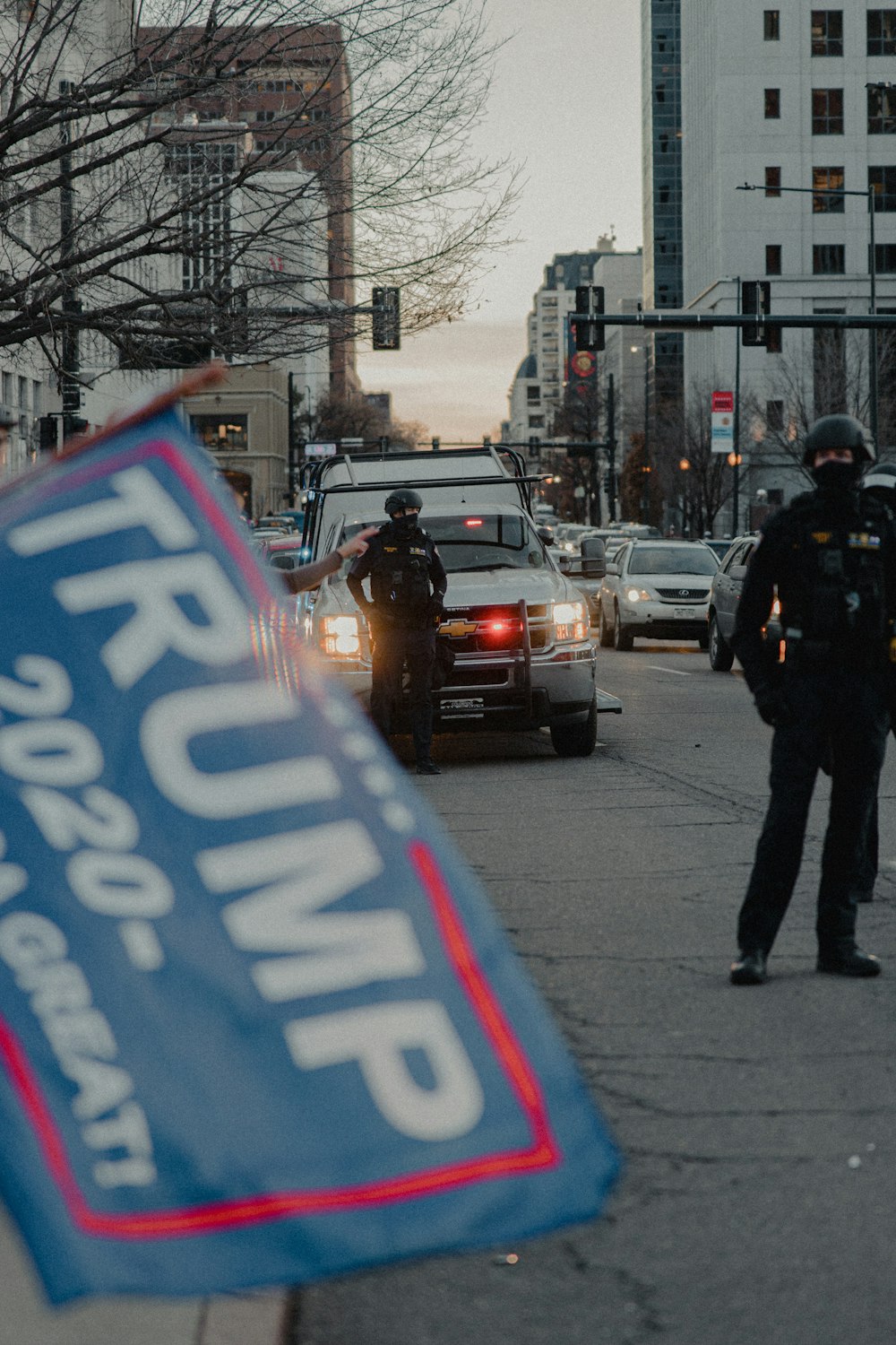 man in black jacket and black pants standing on sidewalk during daytime