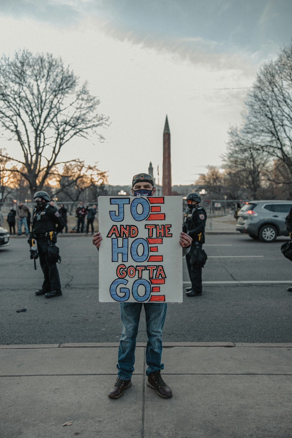 man in white and black jacket holding white and black signage